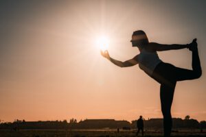 Junge Frau in Yoga Asana Tänzer mit Sonne in Hand Ziele setzen und erreichen